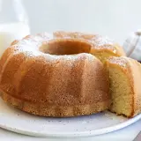 En gyllene sockerkaka med pudersocker, perfekt för ett enkelt sockerkaka recept. En bit är uppskuren.