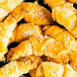 En hög med gyllene gifflar med mandelmassa, toppade med pärlsocker. Perfekta till fikat!
