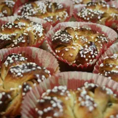 En hel bricka med nybakade kanelbullar, toppade med pärlsocker. Perfekt för att fundera på vilken jäst till kanelbullar som ger bäst resultat.