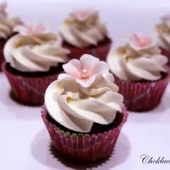 Sju små mini cupcakes med vit frosting och rosa blommor. Perfekta för ett sött kalas.