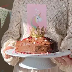 En chokladtårta med enhörningsdekoration och guldkrona, perfekt för roliga kakor barnkalas.