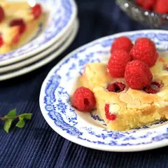 En bit hallonblondie på en blåvit tallrik, perfekt för ett somrigt blondie recept.