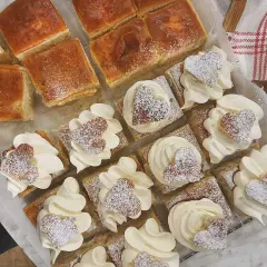 Fredriks fika: små fyrkantiga semlor med fluffig grädde och hjärtformade kakor, pudrade med florsocker. Perfekt för en mysig stund.