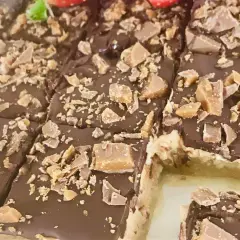 Chokladiga biskvier i långpanna, toppade med krossad choklad och kola. Perfekt för fikat!