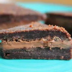 En bit chokladig kladdkaka med krämig fyllning, perfekt för en fika.
