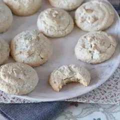 En tallrik med hembakade amaretti-kakor, perfekta för ditt nästa amaretti recept. En kaka är uppäten!