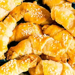En hög med gyllene gifflar med mandelmassa, toppade med pärlsocker. Perfekta till fikat!
