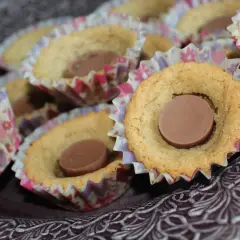 En skål med sega kakor, var och en med en chokladbit i mitten, i färgglada pappersformar.
