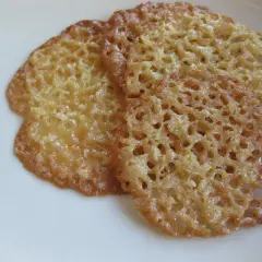 Tre gyllene, krispiga havreflarn ligger på en vit tallrik. Perfekta för ett enkelt recept på havreflarn.