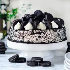 En imponerande oreo tårta, täckt med krossade kakor och dekorerad med hela oreos och fluffig grädde. En dröm för alla chokladälskare!