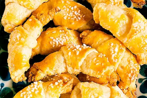 En hög med gyllene gifflar med mandelmassa, toppade med pärlsocker. Perfekta till fikat!