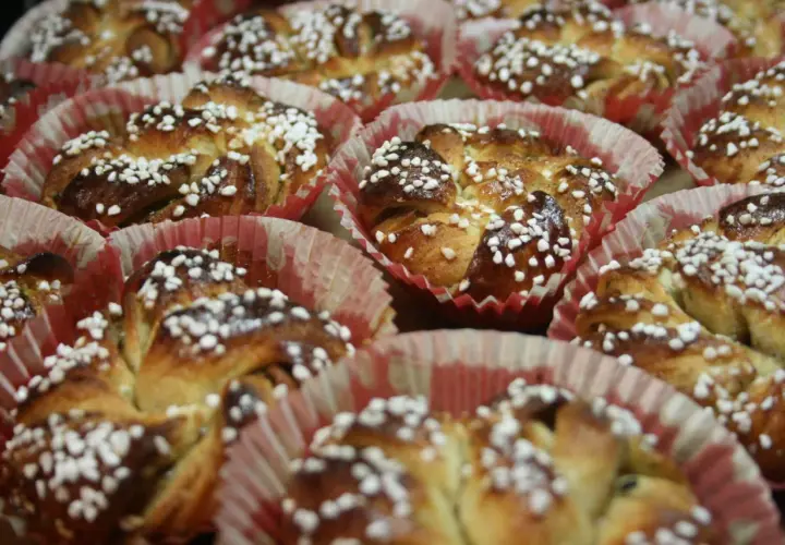 En hel bricka med nybakade kanelbullar, toppade med pärlsocker. Perfekt för att fundera på vilken jäst till kanelbullar som ger bäst resultat.