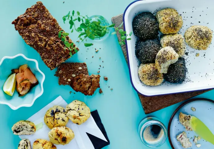 En härlig frukost med knäckebröd bakat på specialmjöl, bullar med frön, rökt lax och kaffe.