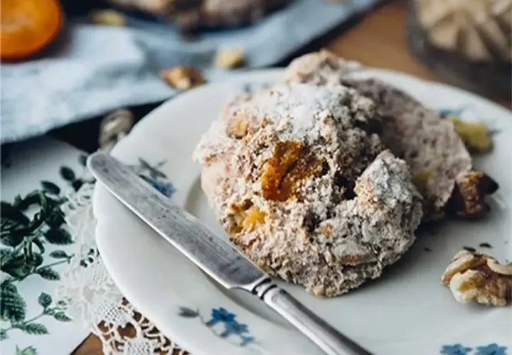En tallrik med bullar, pudrade med florsocker. Kan man använda jäst för matbröd till bullar? Ja, det går utmärkt!