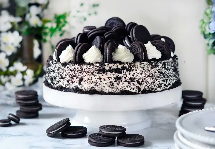 En imponerande oreo tårta, täckt med krossade kakor och dekorerad med hela oreos och fluffig grädde. En dröm för alla chokladälskare!