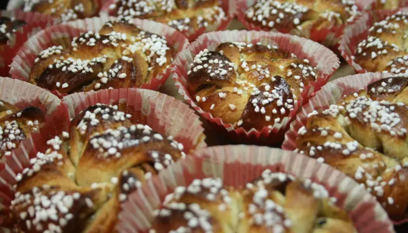 En hel bricka med nybakade kanelbullar, toppade med pärlsocker. Perfekt för att fundera på vilken jäst till kanelbullar som ger bäst resultat.