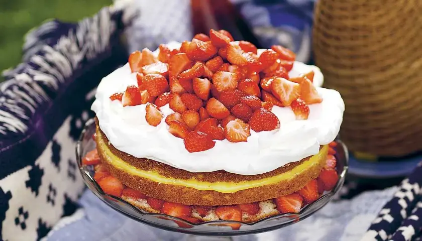 En härlig jordgubbstårta med fluffig grädde och en syrlig lemoncurd som överraskar. Perfekt för sommaren!