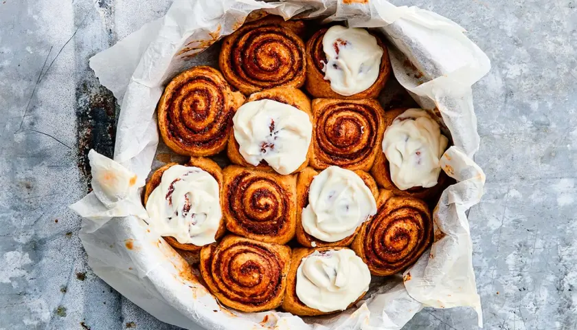 Kanelbullar med glasyr i en form, redo att frysa bulldeg för senare njutning.