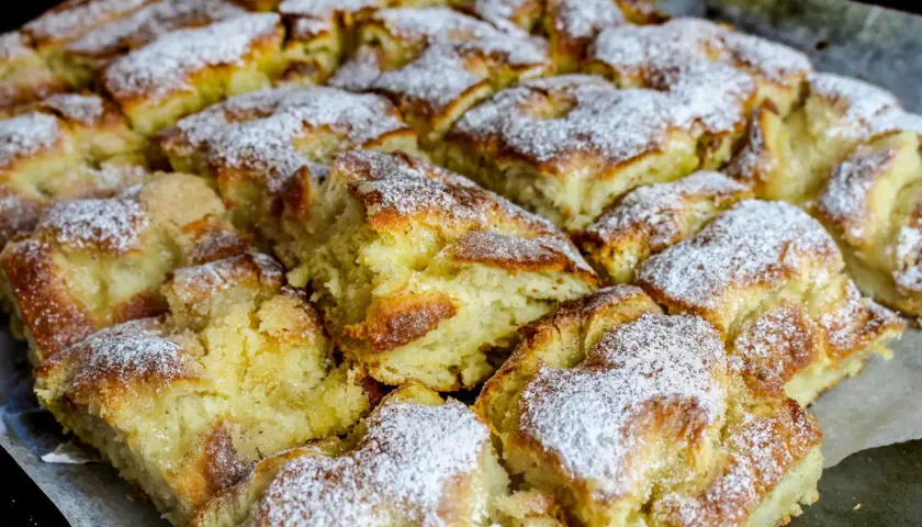 Nybakade bullar med vaniljkräm i långpanna, pudrade med florsocker. En härlig syn för alla bullälskare!