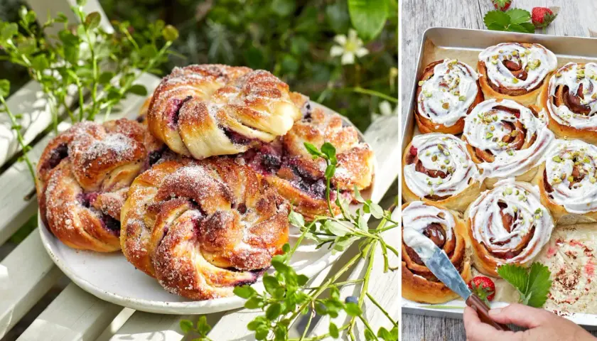 Fyllda bullar med bär och socker på en vit tallrik, bredvid en plåt med kanelbullar med glasyr och pistagenötter.