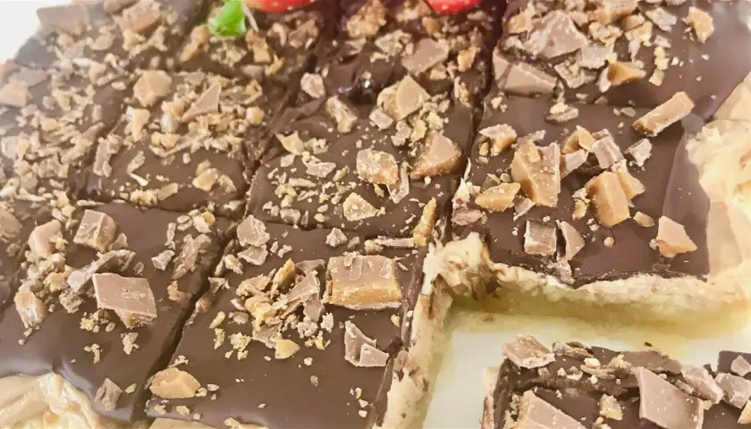 Chokladiga biskvier i långpanna, toppade med krossad choklad och kola. Perfekt för fikat!