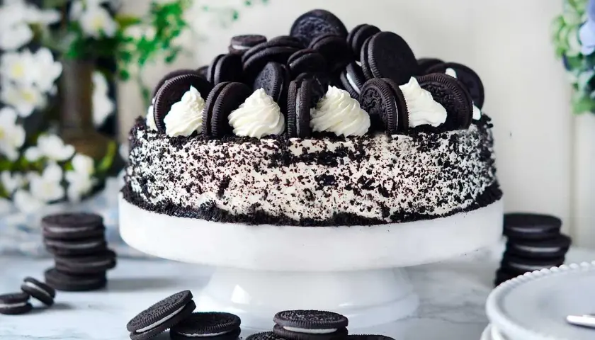 En imponerande oreo tårta, täckt med krossade kakor och dekorerad med hela oreos och fluffig grädde. En dröm för alla chokladälskare!