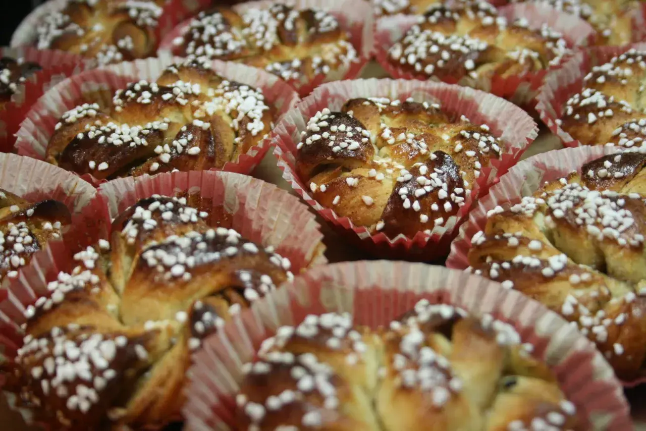 En hel bricka med nybakade kanelbullar, toppade med pärlsocker. Perfekt för att fundera på vilken jäst till kanelbullar som ger bäst resultat.