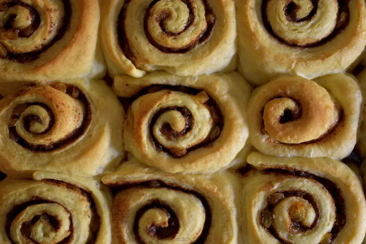 Nybakade kanelbullar med russin, redo att avnjutas. Doften av kanel sprider sig i köket.