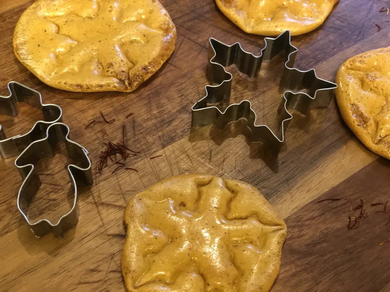 Dalgona-kakor med stjärn- och pepparkaksgubbeformar, redo att bakas.