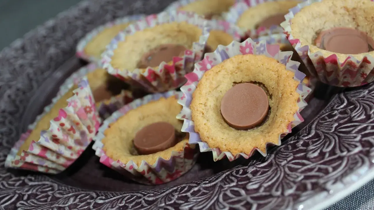 En skål med sega kakor, var och en med en chokladbit i mitten, i färgglada pappersformar.