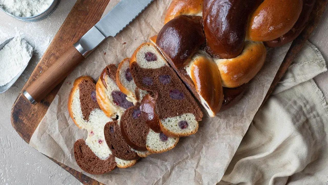 En vackert flätad vetelängd med mandelmassa och mörka bär. Skivorna visar en härlig kontrast mellan ljust och mörkt bröd.