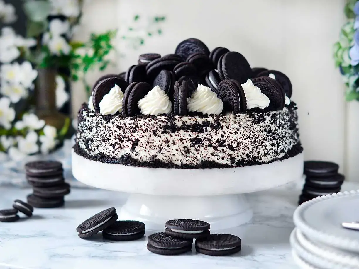 En imponerande oreo tårta, täckt med krossade kakor och dekorerad med hela oreos och fluffig grädde. En dröm för alla chokladälskare!