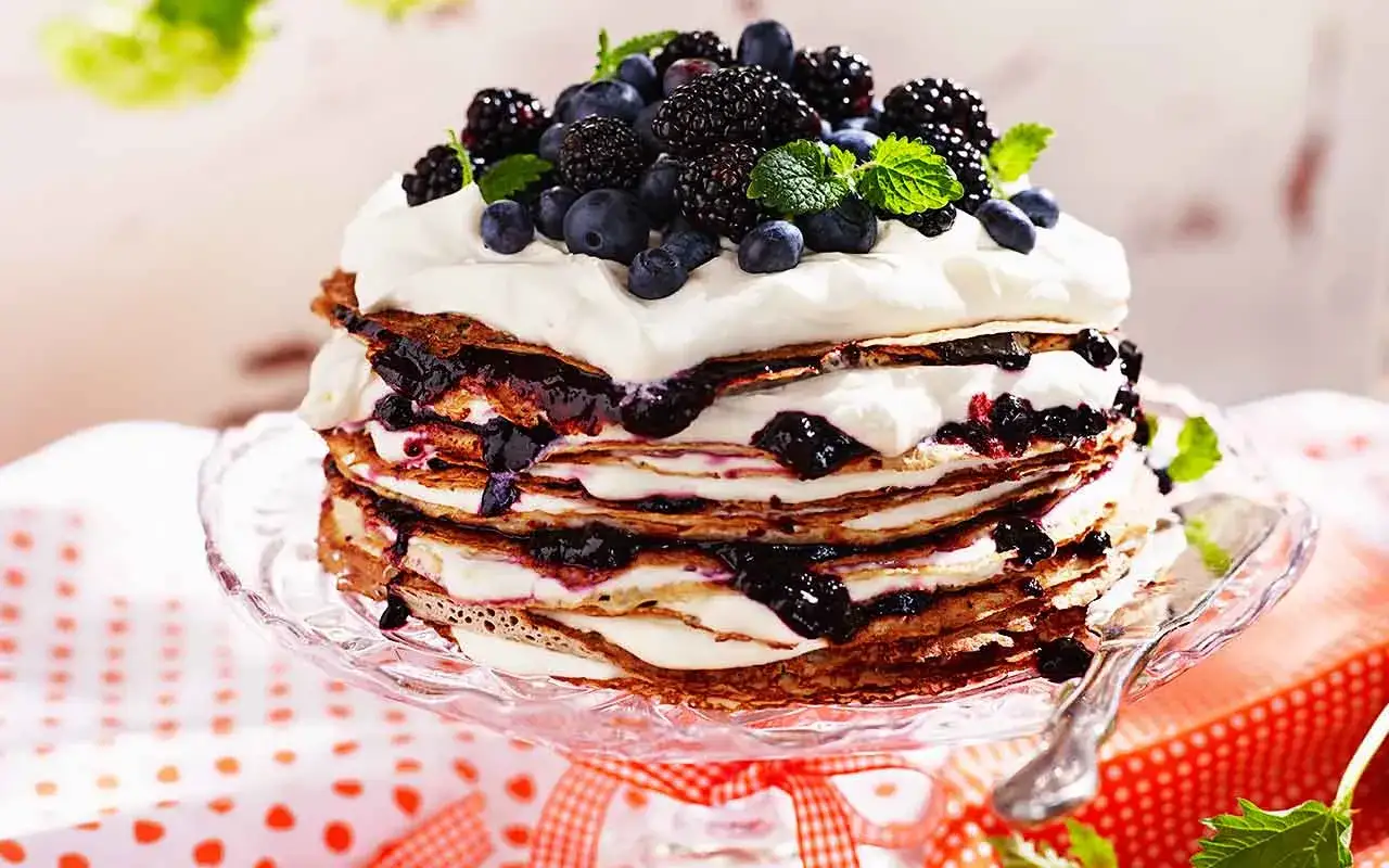 En imponerande pannkakst&aring;rta med fluffig gr&auml;dde och b&auml;r. Ett perfekt pannkakst&aring;rta recept f&ouml;r festliga tillf&auml;llen.