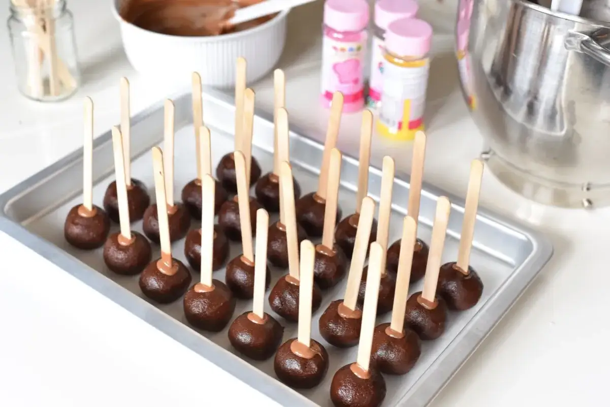Chokladbollar p&aring; pinnar, redo att dekoreras. En bricka full med dessa l&auml;ckra cake pops v&auml;ntar p&aring; att bli kl&auml;dda i f&auml;rg.