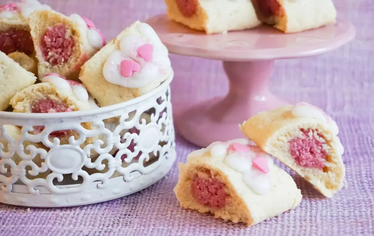 Annorlunda sm&aring;kakor med rosa fyllning och hj&auml;rtdekorationer i vit glasyr.