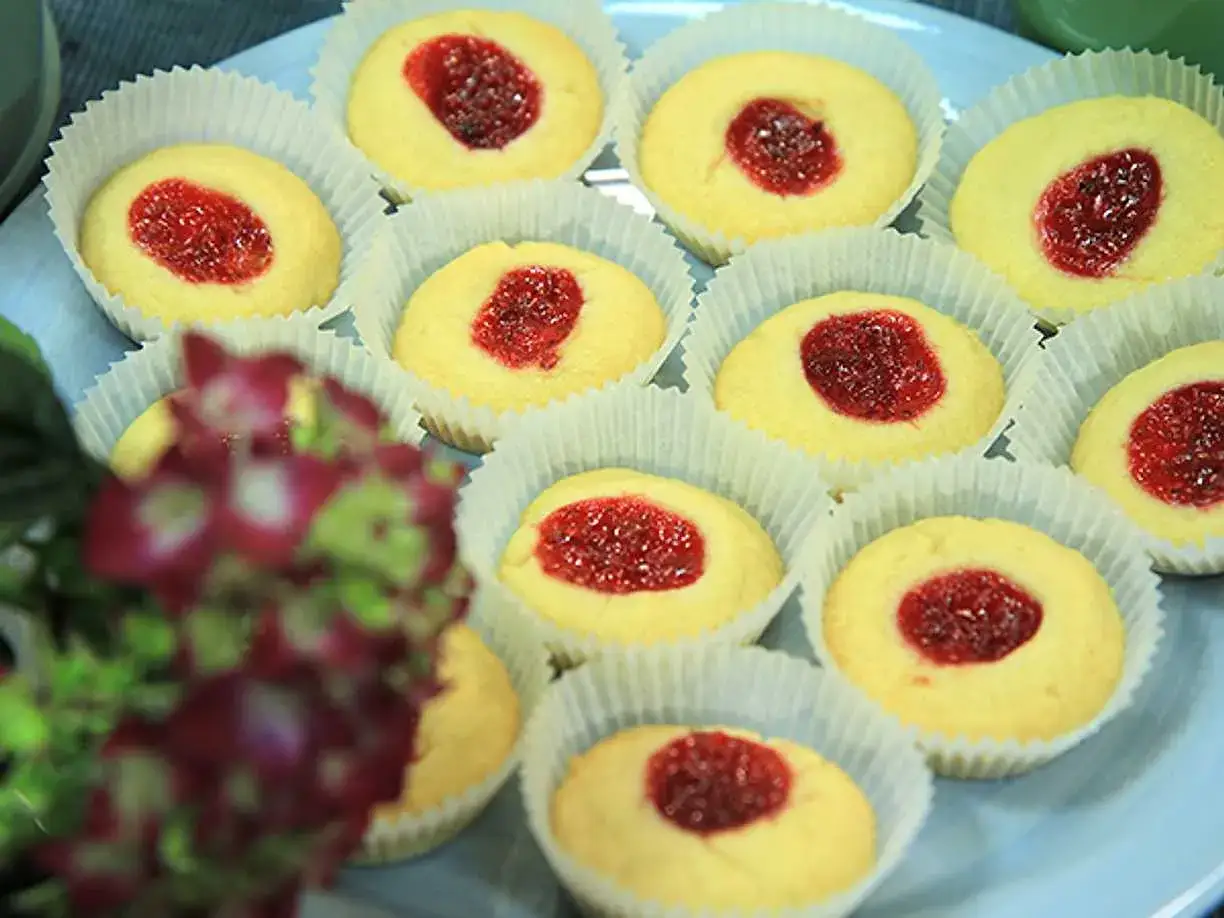 Hallongrottor recept: små, runda kakor med syltkärna i pappersformar, redo att avnjutas.