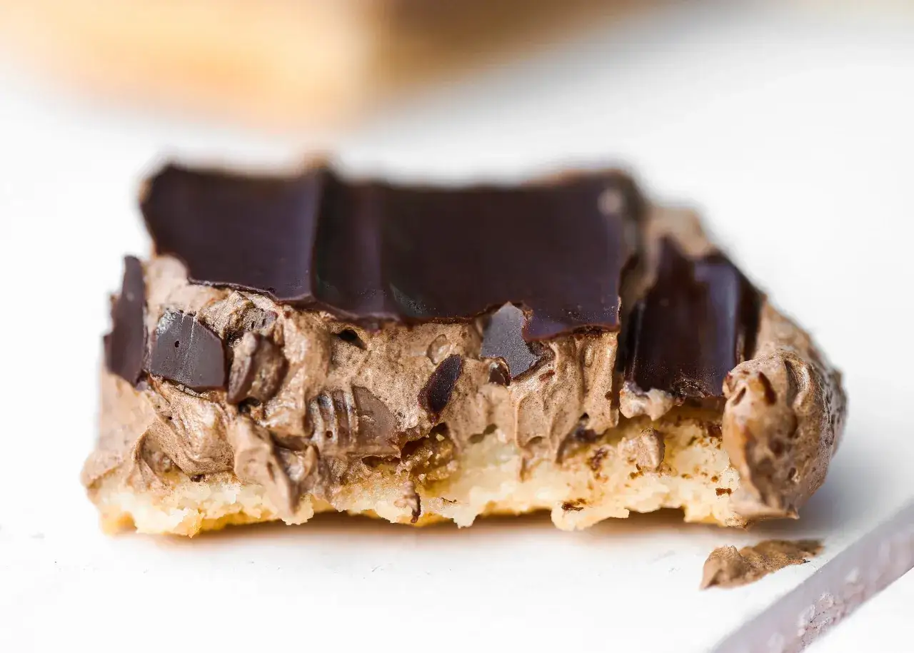 En bit av en chokladbiskvi i l&aring;ngpanna med kr&auml;mig chokladmousse och m&ouml;rk chokladglasyr.
