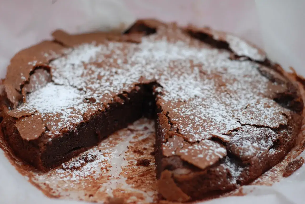 En saftig kladdkaka t&aring;rta, pudrad med florsocker, ser oemotst&aring;ndlig ut.