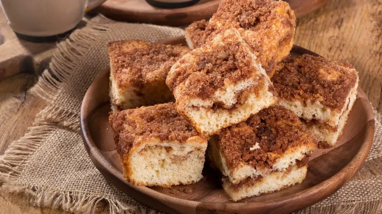 En skiva saftig sockerkaka med kanelsmul, serverad p&aring; en tr&auml;bricka med en jutduk. Perfekt till fikat!